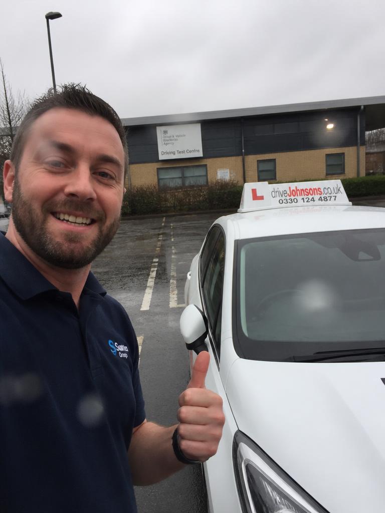 Marek holding their driving test pass certificate in Leeds