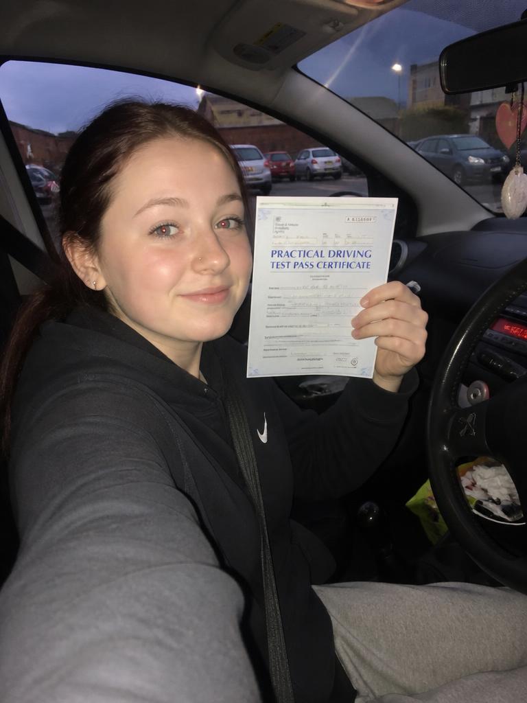 Aimee holding their driving test pass certificate in Bristol