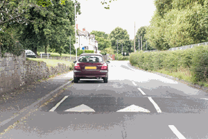 Illustration for the theory test question: When there are traffic-calming measures in place, how should you drive?