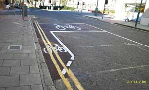 Illustration for the theory test question: This junction, controlled by traffic lights, has a marked area between two stop lines. What’s this for?