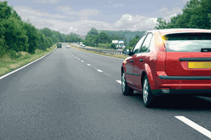 Illustration for the theory test question: You are driving along this road and the red car cuts in sharply before you. How should you react?